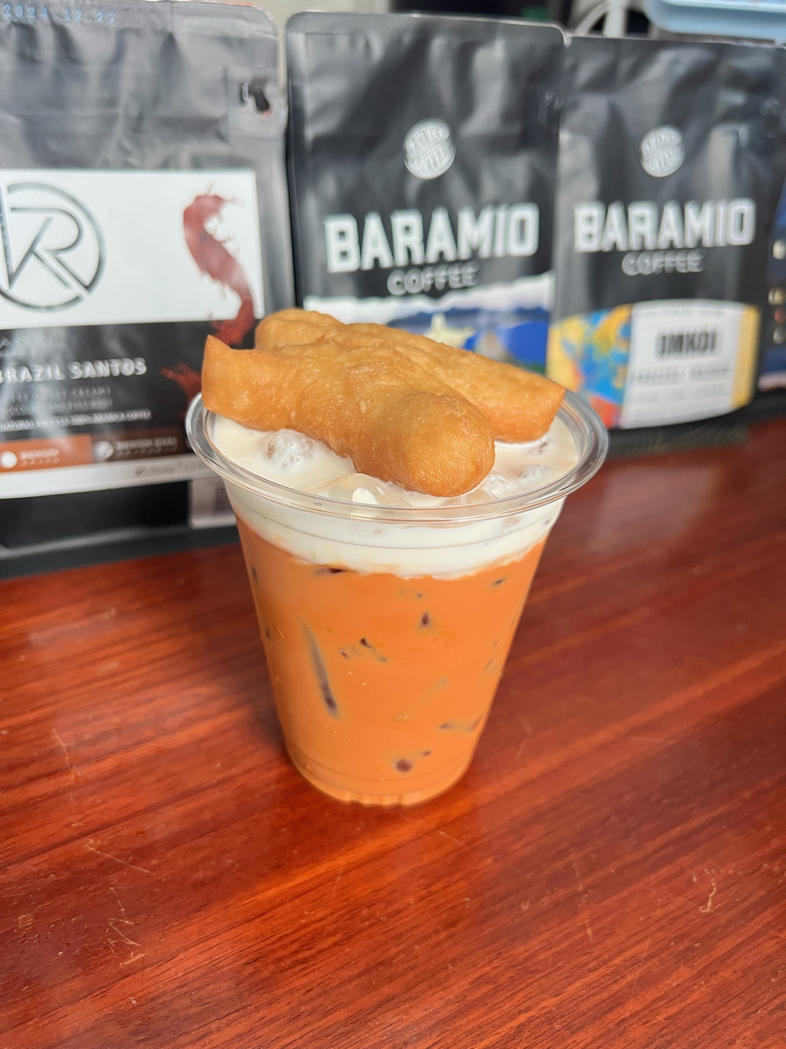A colorful iced drink topped with fried dough at a local coffee shop