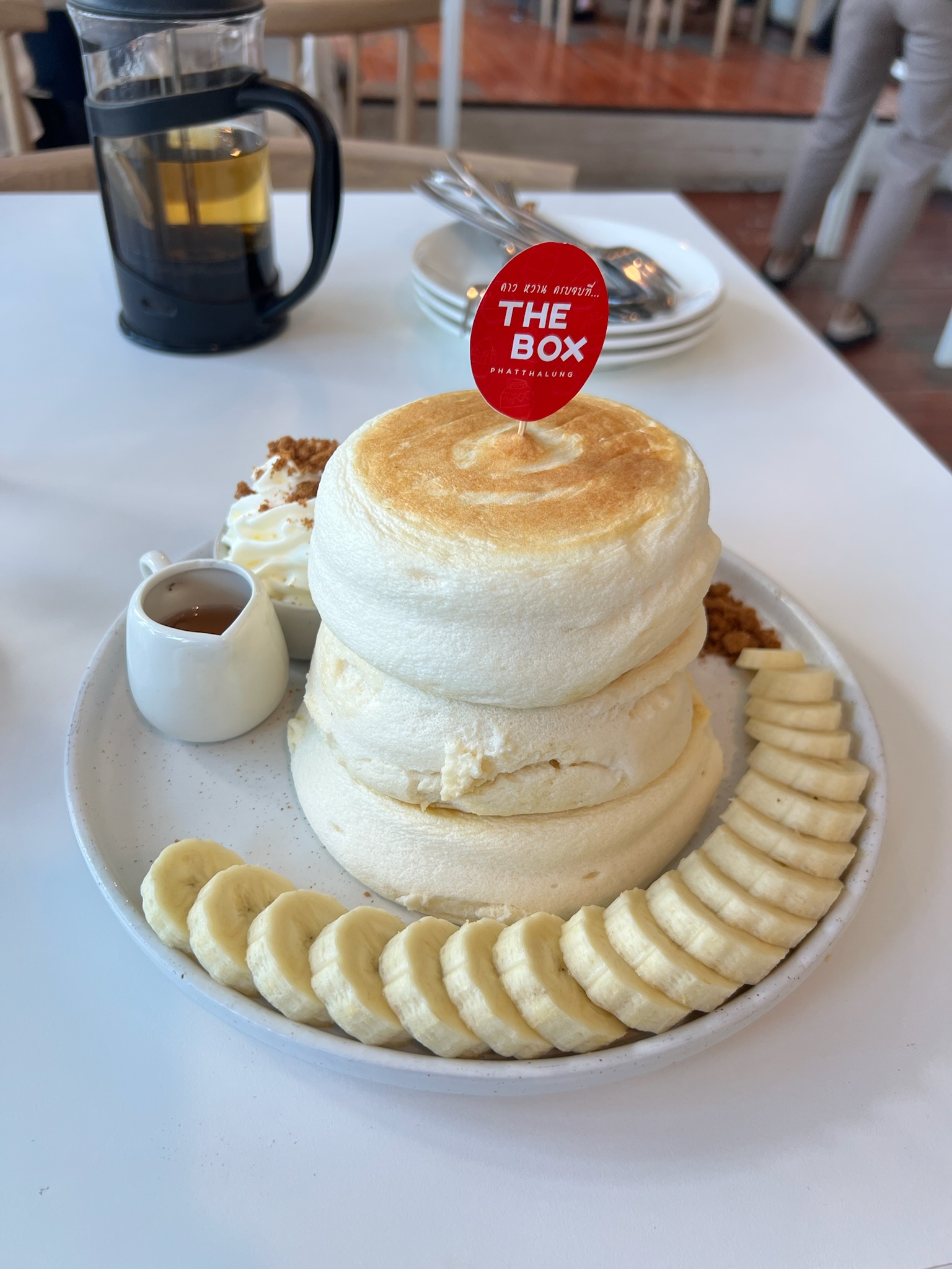 A tall stack of fluffy pancakes at The Box Phatthalung