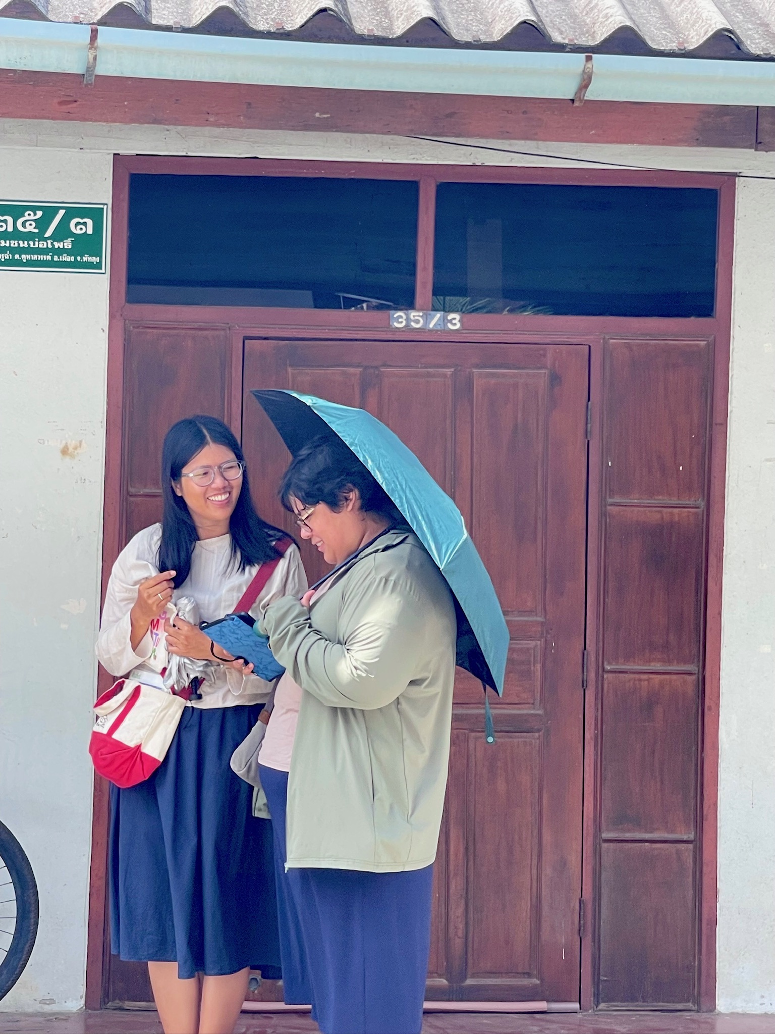 Two friends sharing a laugh beneath an umbrella