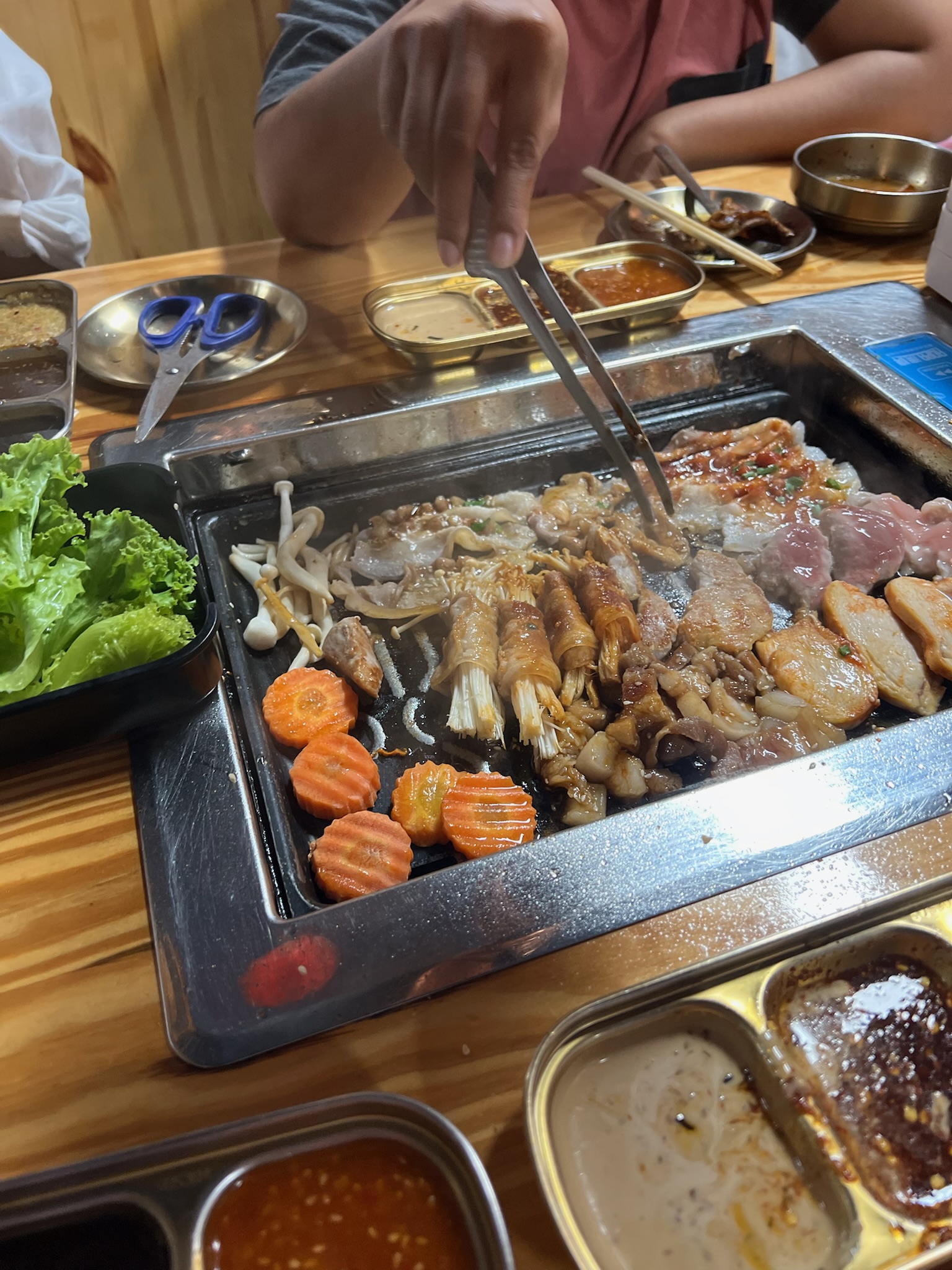Friends cooking together around a tabletop grill