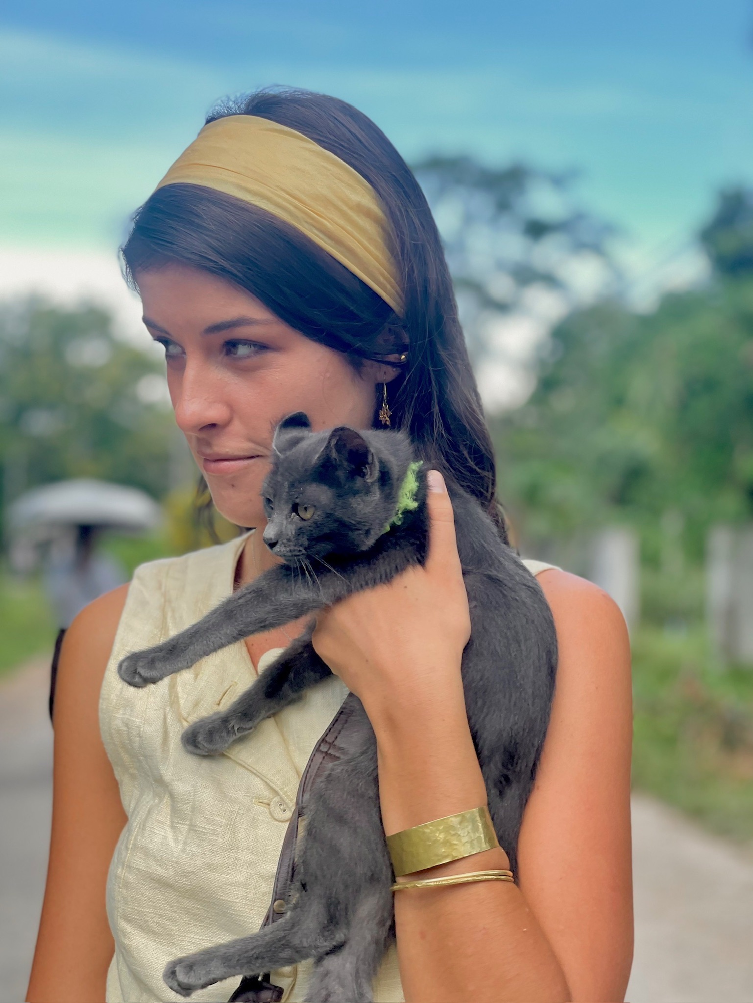 A friend holding a small grey kitten