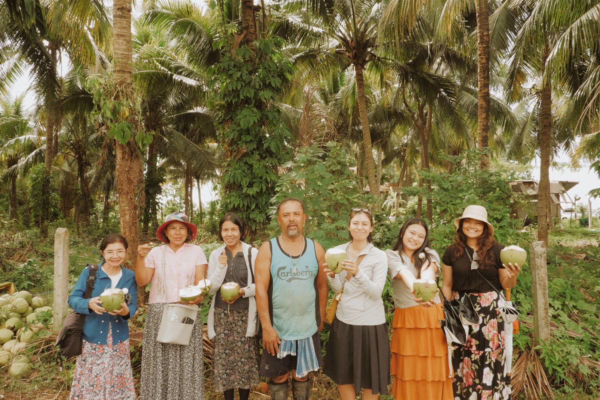 Friends sharing fresh coconuts beneath the palm trees
