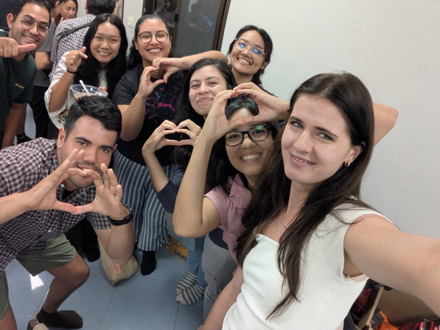 Young friends making heart shapes together for a cheerful selfie