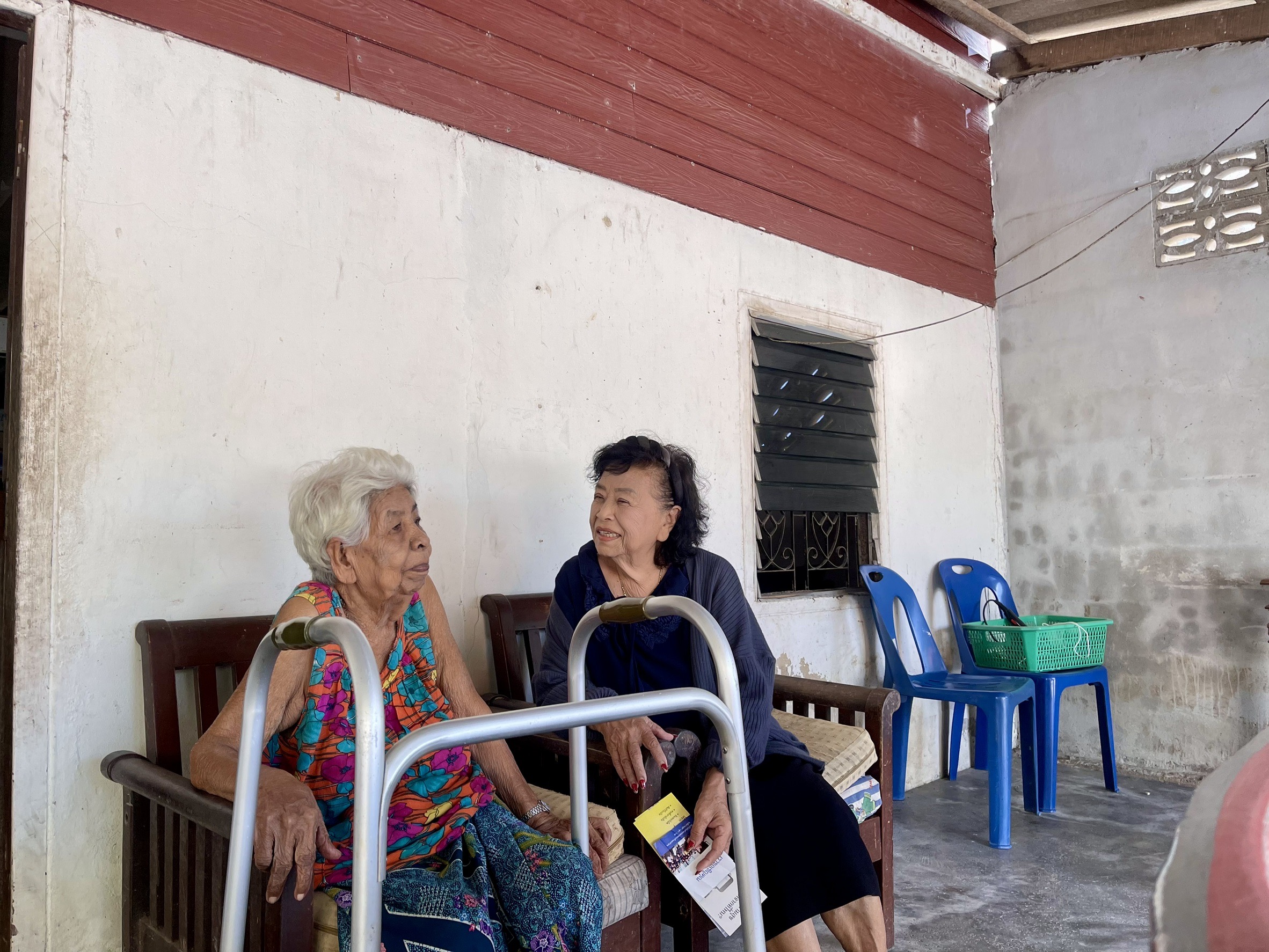 Two older women enjoying a warm conversation during a visit
