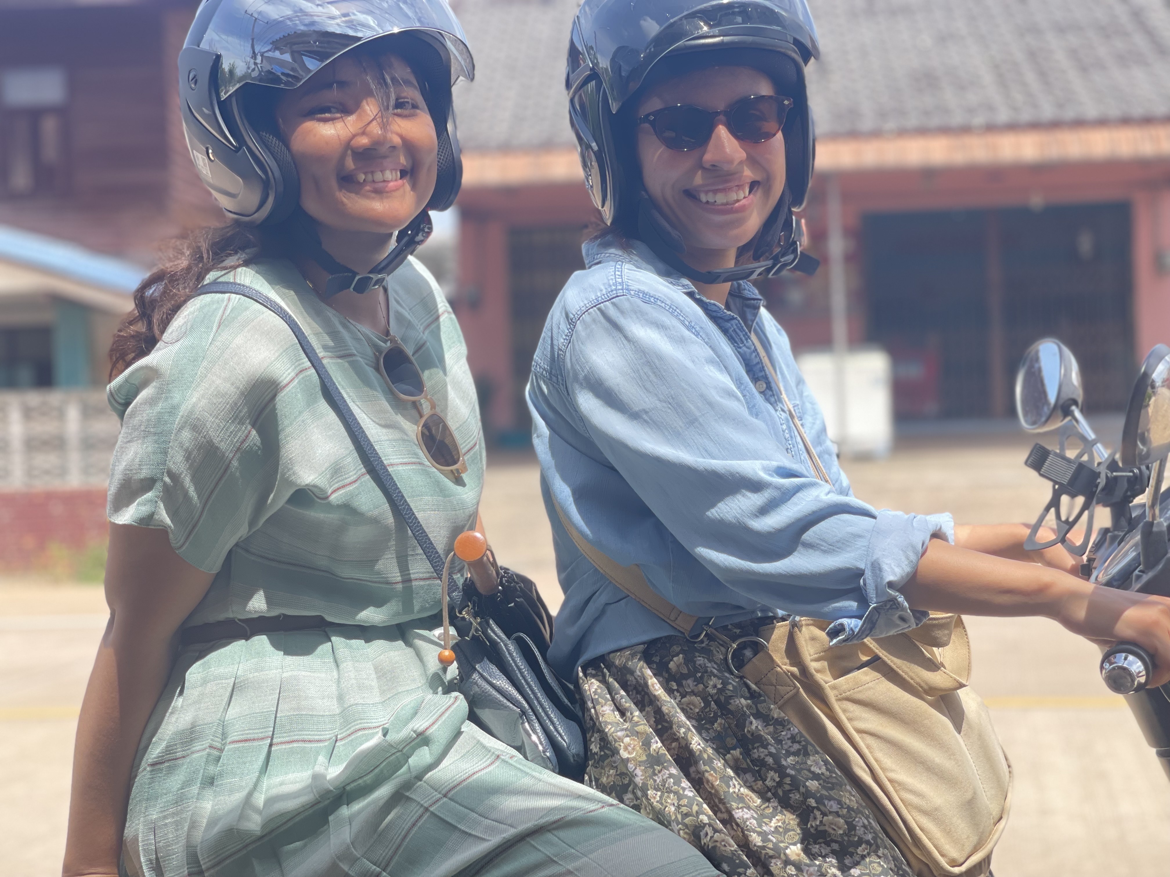 Two friends smiling together on a motorbike