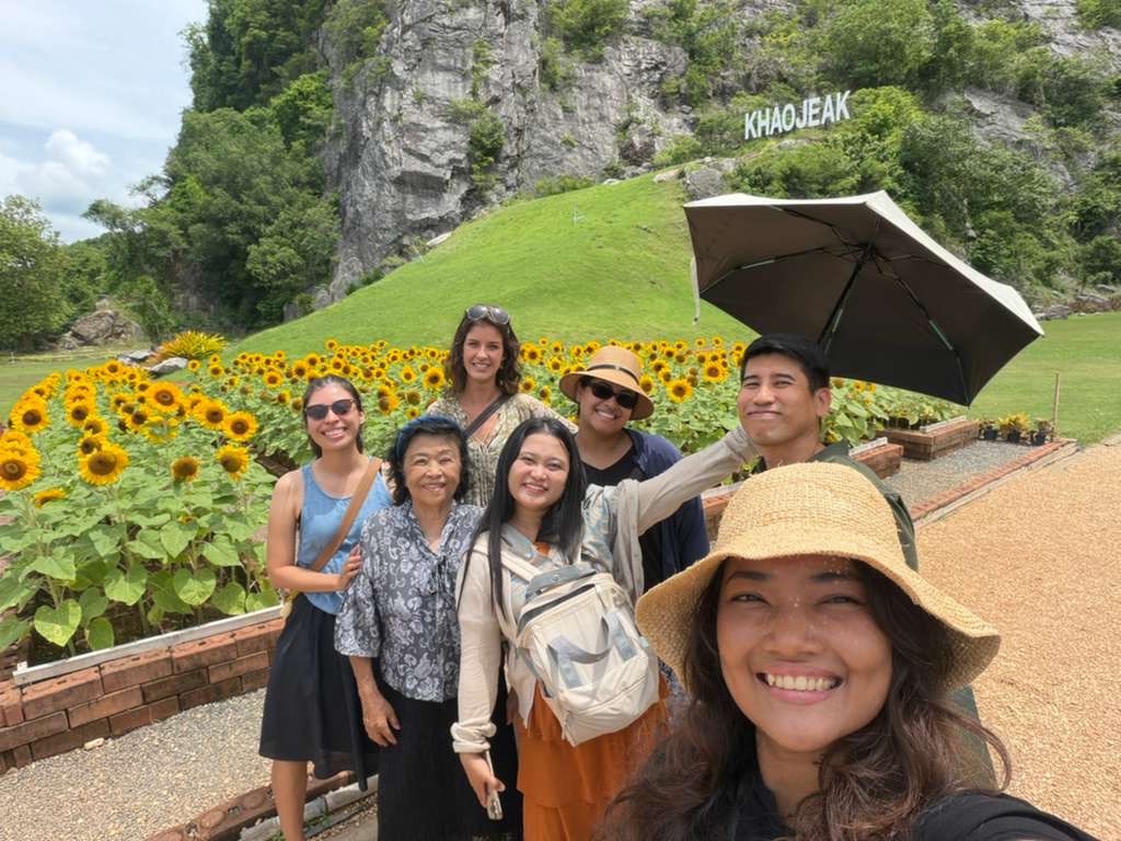Friends smiling together in a sunflower garden